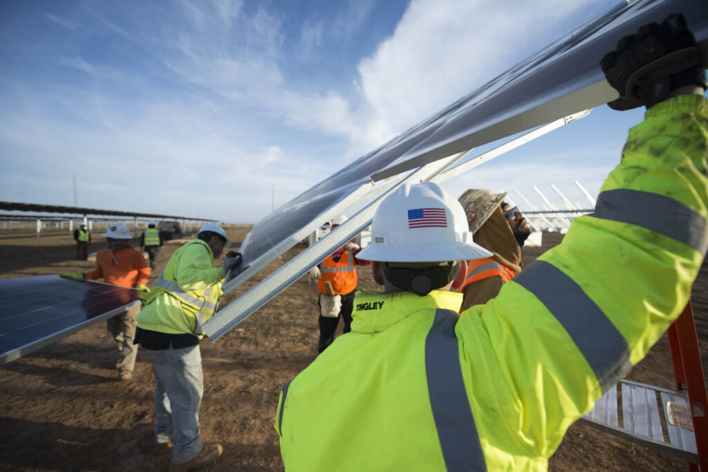 workers installing solar panels