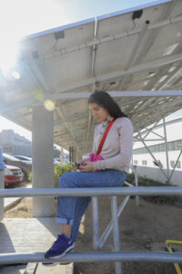 woman sitting under solar panels