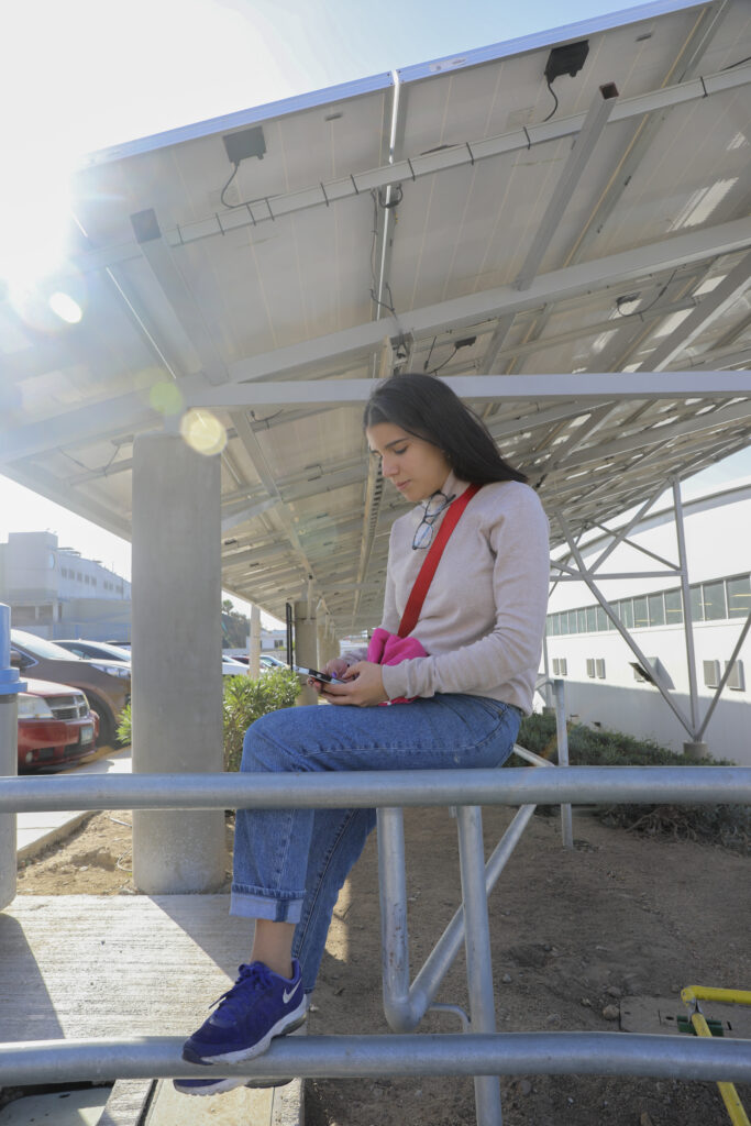 woman sitting under solar panels